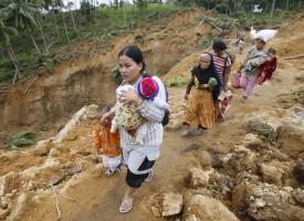 Ženy odcházející z jedné ze zničených vesnic.